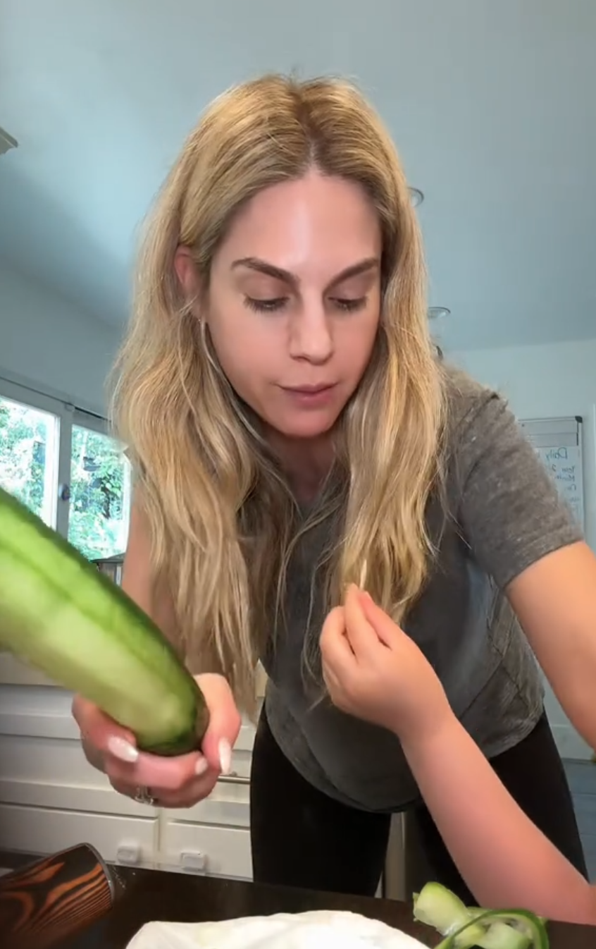 Woman peeling cucumber